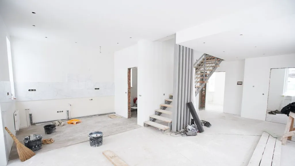 Post-construction cleaning in Florida — newly built home interior with bare drywall, staircase and construction debris ready for Captain Duster's final clean